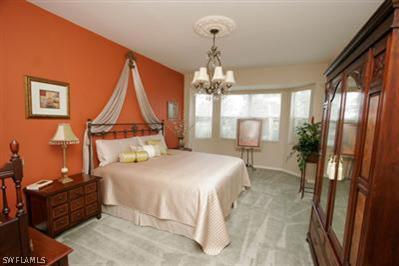 15057 Balmoral Loop Fort Myers, FL 33919 - Photo 9 of 10 a bedroom with a bed and dresser with chair