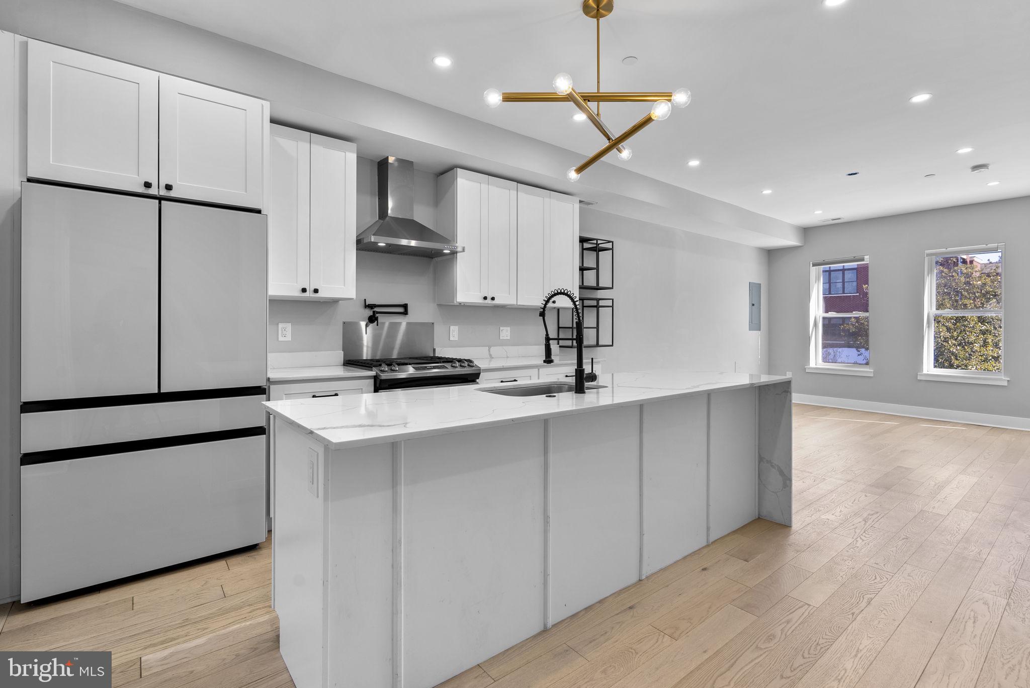 3572 13th Street Northwest, Unit 2 Washington, DC 20010 - Photo 11 of 36 a kitchen with stainless steel appliances granite countertop a sink a stove a refrigerator and island with wooden floor