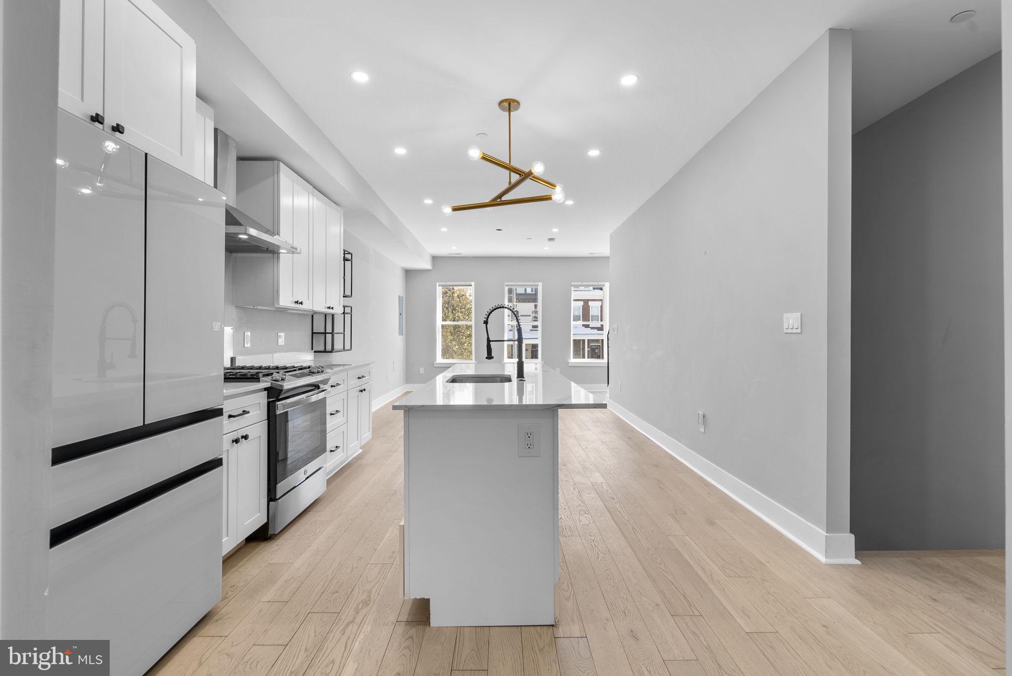 3572 13th Street Northwest, Unit 2 Washington, DC 20010 - Photo 12 of 36 a large kitchen with cabinets wooden floor and stainless steel appliances