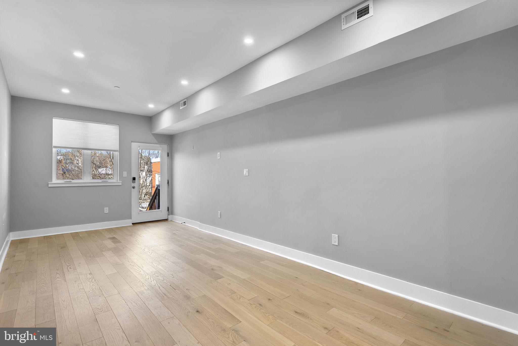 3572 13th Street Northwest, Unit 2 Washington, DC 20010 - Photo 15 of 36 an empty room with wooden floor and windows