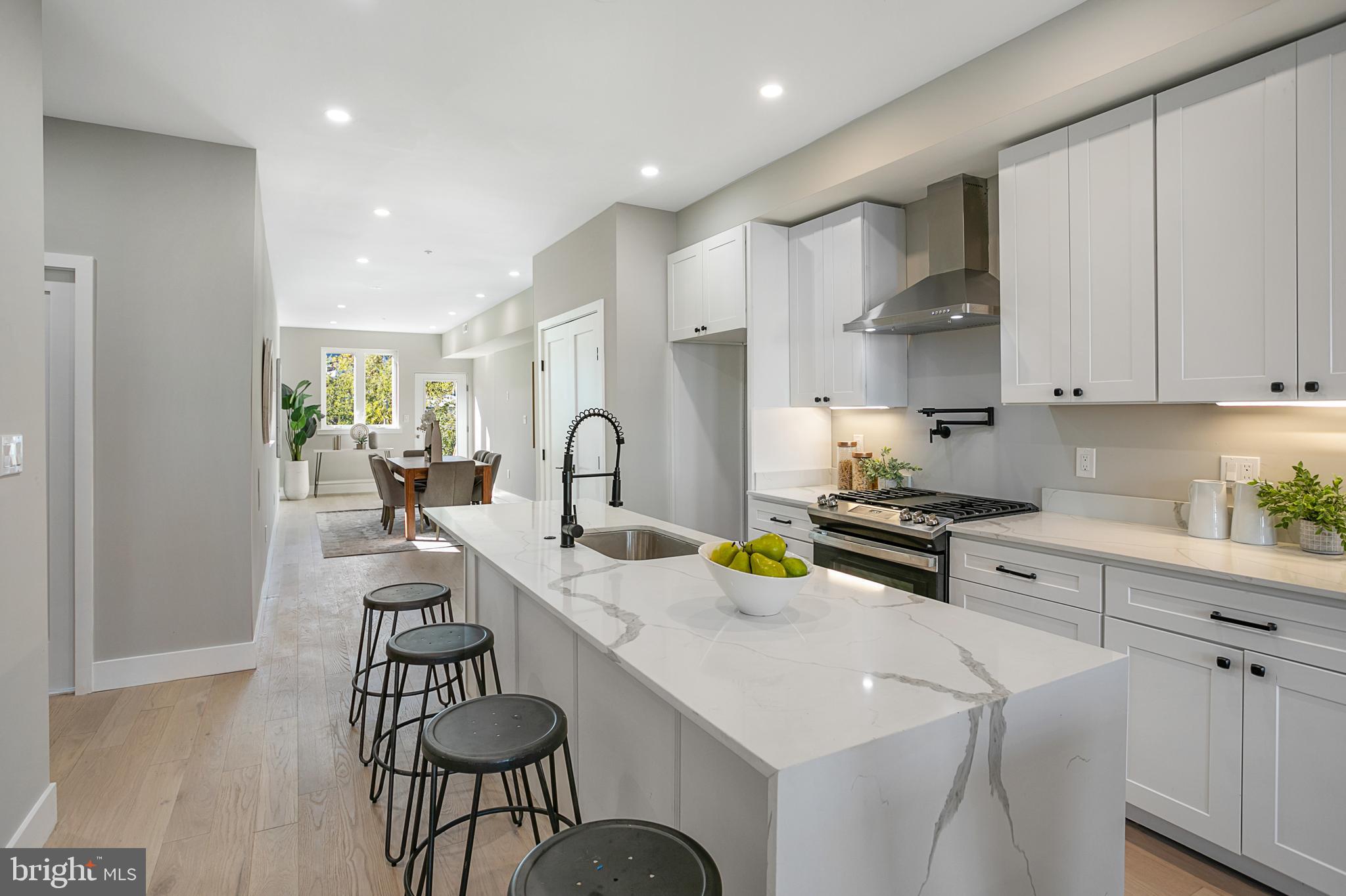 3572 13th Street Northwest, Unit 2 Washington, DC 20010 - Photo 4 of 9 a kitchen with stainless steel appliances a sink a stove a table and chairs