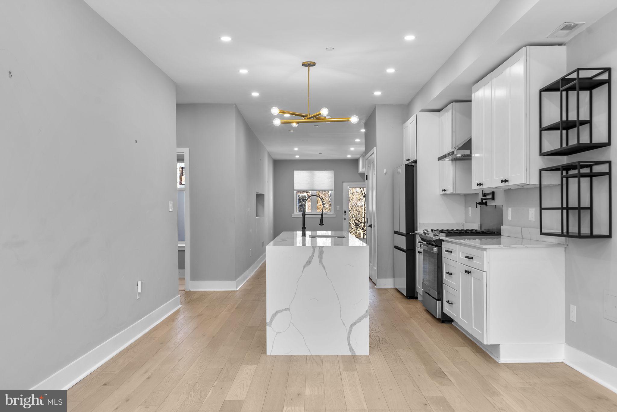 3572 13th Street Northwest, Unit 2 Washington, DC 20010 - Photo 10 of 36 a large white kitchen with kitchen island a stove a sink dishwasher and a refrigerator with wooden floor