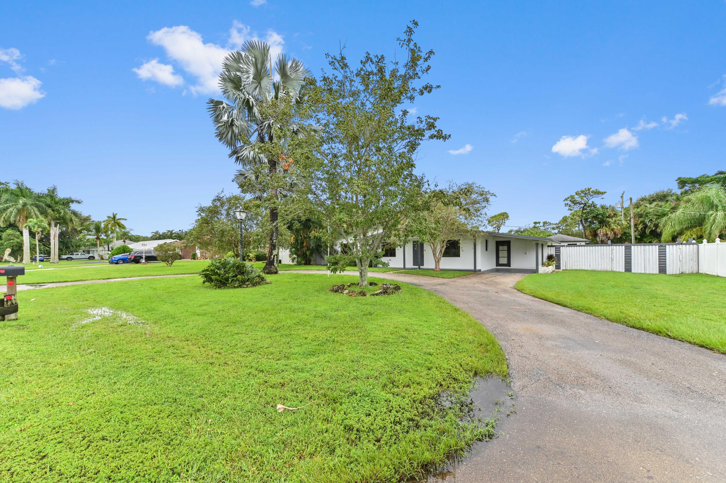98 Cleveland Road Lake Worth, FL 33467 - Photo 1 of 30 a front view of a house with garden