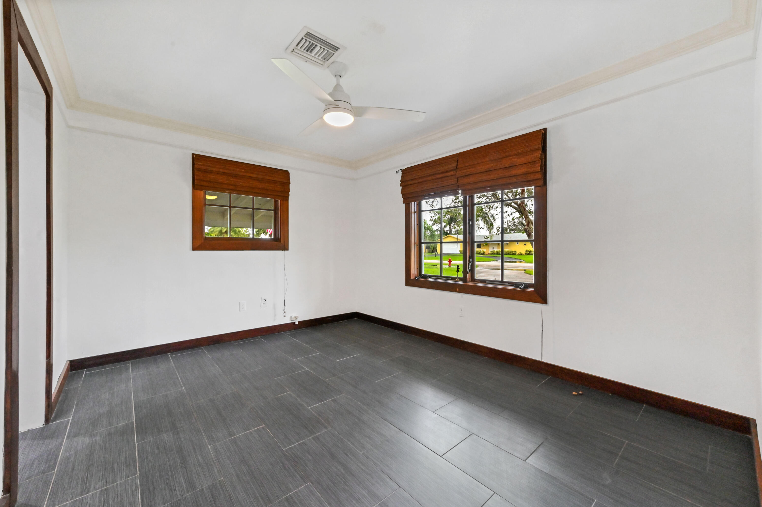 98 Cleveland Road Lake Worth, FL 33467 - Photo 19 of 30 a view of an empty room with a window and wooden floor