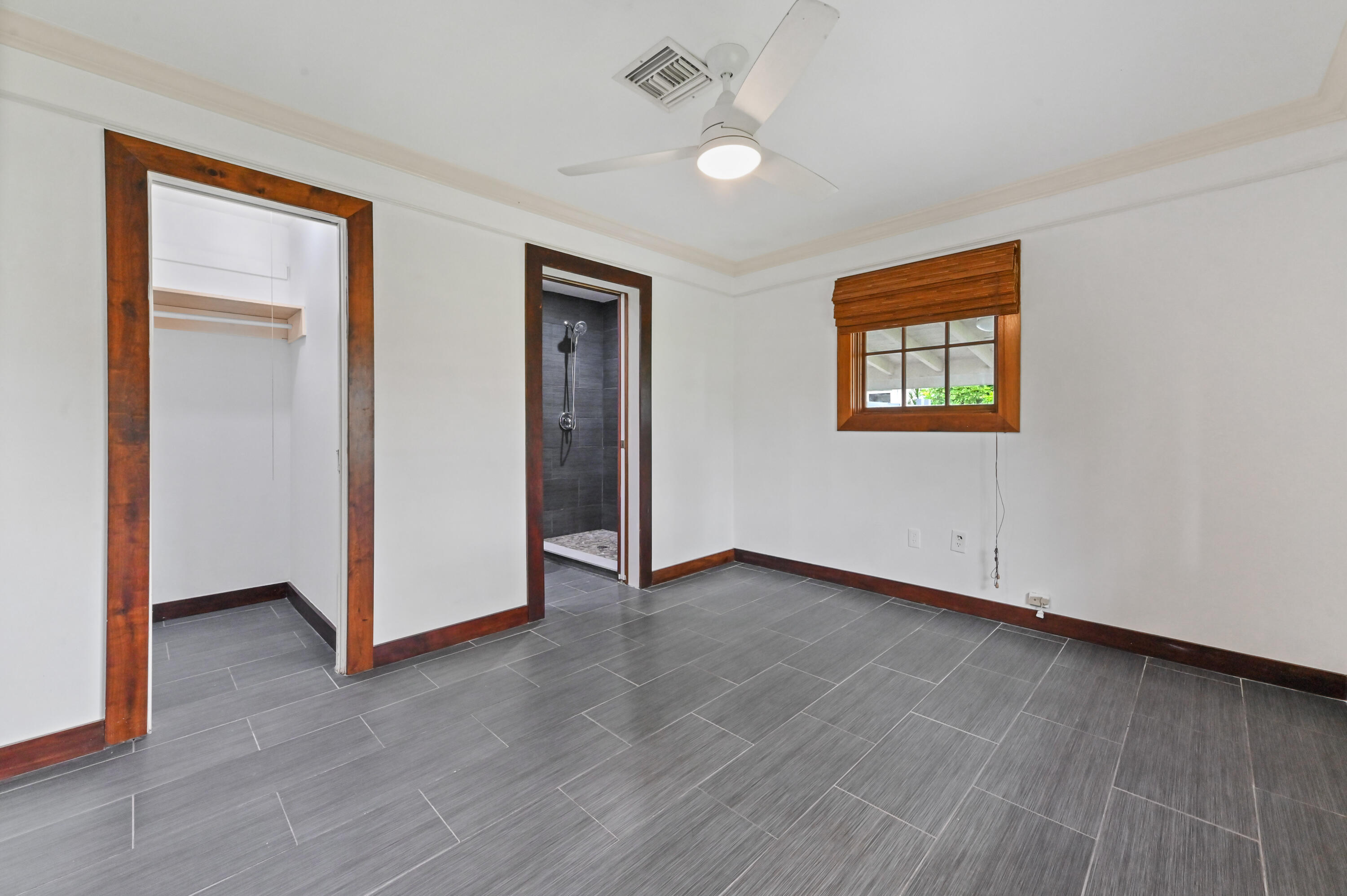 98 Cleveland Road Lake Worth, FL 33467 - Photo 20 of 30 a view of an empty room with wooden floor and a ceiling fan