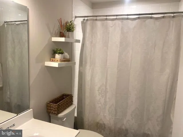 a bathroom with a shower curtain and toilet