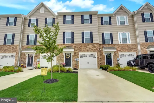 a front view of a house with a yard and trees