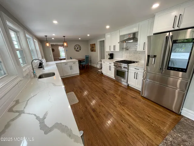 a kitchen with stainless steel appliances a refrigerator sink and microwave