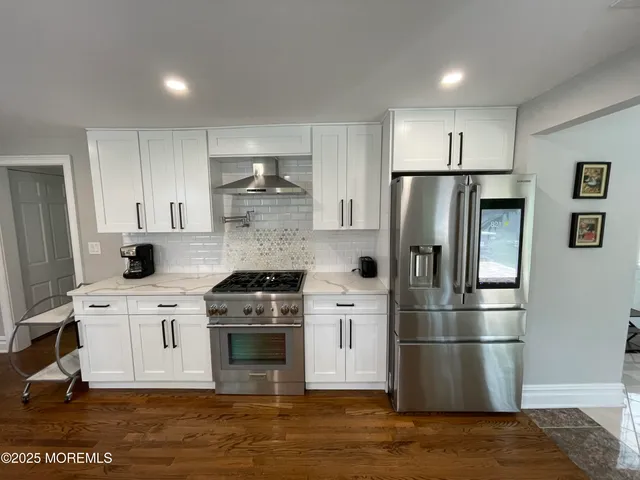 a kitchen with a white cabinets and wooden floor