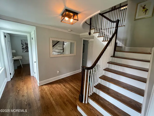 a view of entryway and hall with wooden floor