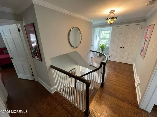 a view of a hallway with wooden floor and stairs