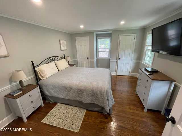 a bedroom with a bed window and a flat screen tv