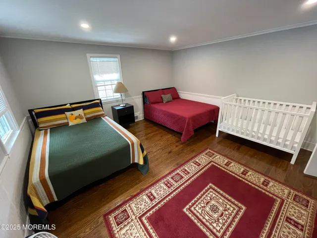 a bedroom with two beds and wooden floor