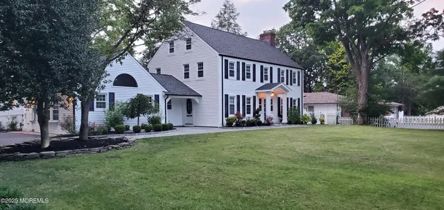 a view of a house with a yard and pathway