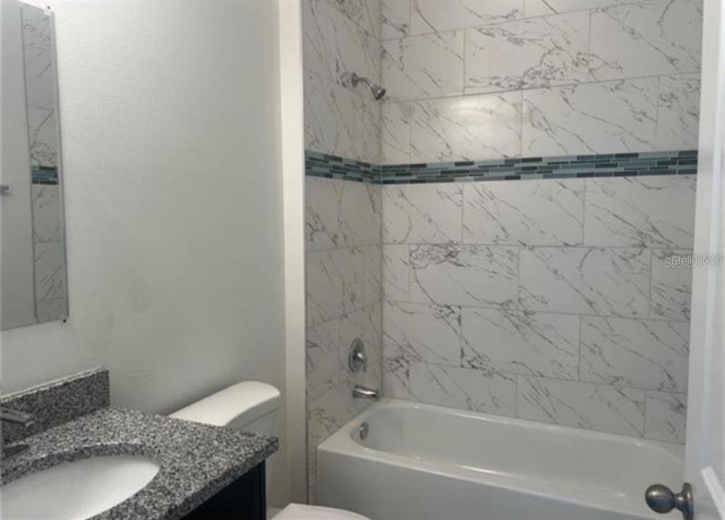 16262 Southwest 21st Terrace Road Ocala, FL 34473 - Photo 23 of 25 a bathroom with a granite countertop bathtub shower sink and vanity