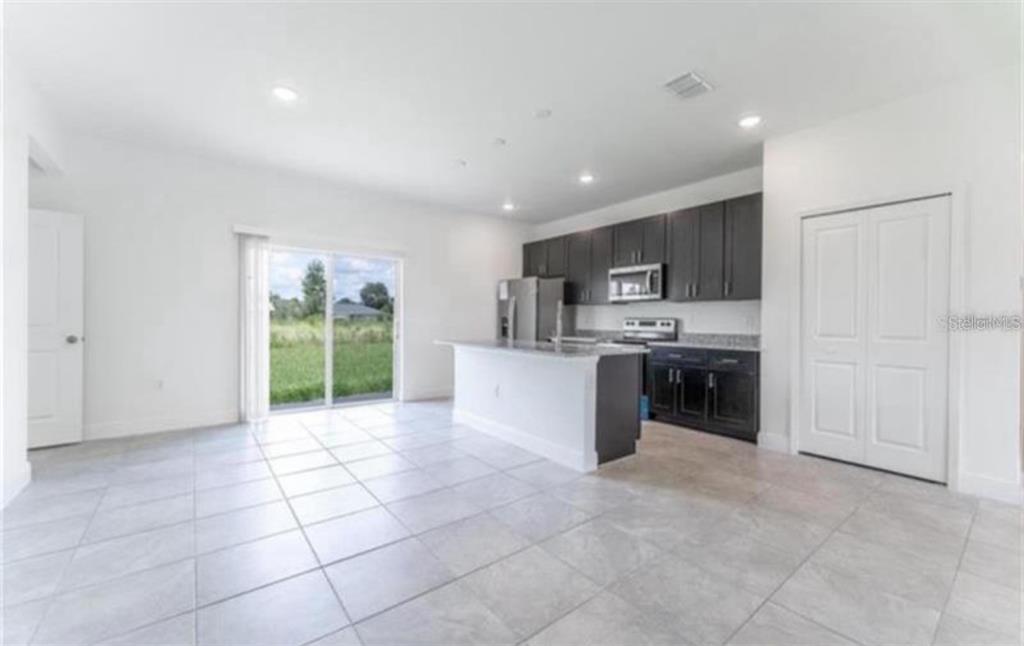 16262 Southwest 21st Terrace Road Ocala, FL 34473 - Photo 10 of 25 a kitchen with stainless steel appliances a sink a stove a microwave a refrigerator and cabinets