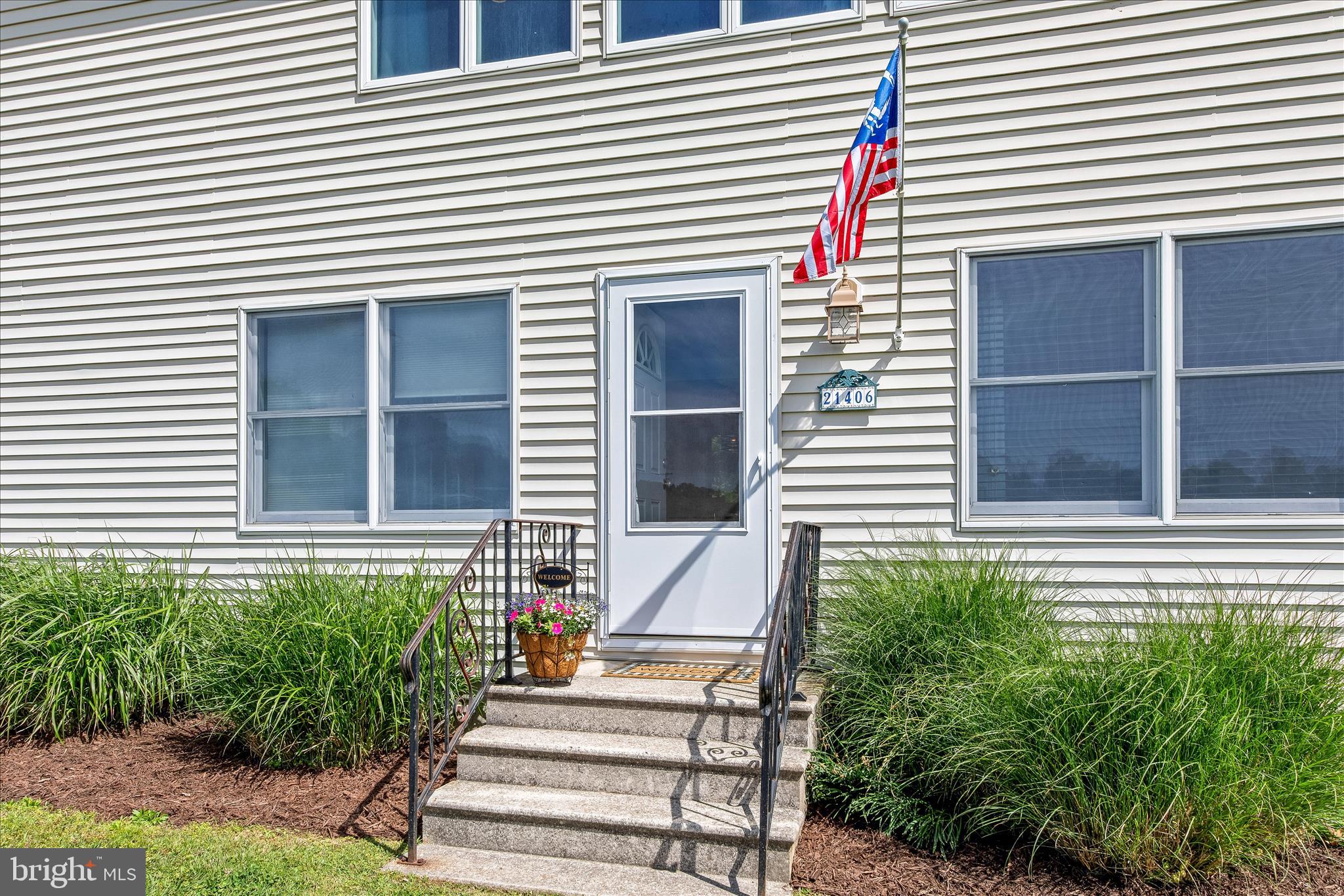 21406 Dogwood Cove Road Tilghman, MD 21671 - Photo 5 of 68 a front view of a house with a yard and potted plants