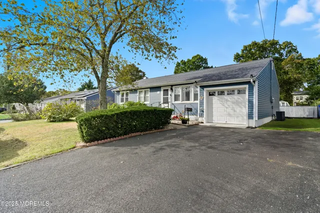 a view of a house with a yard and potted plants