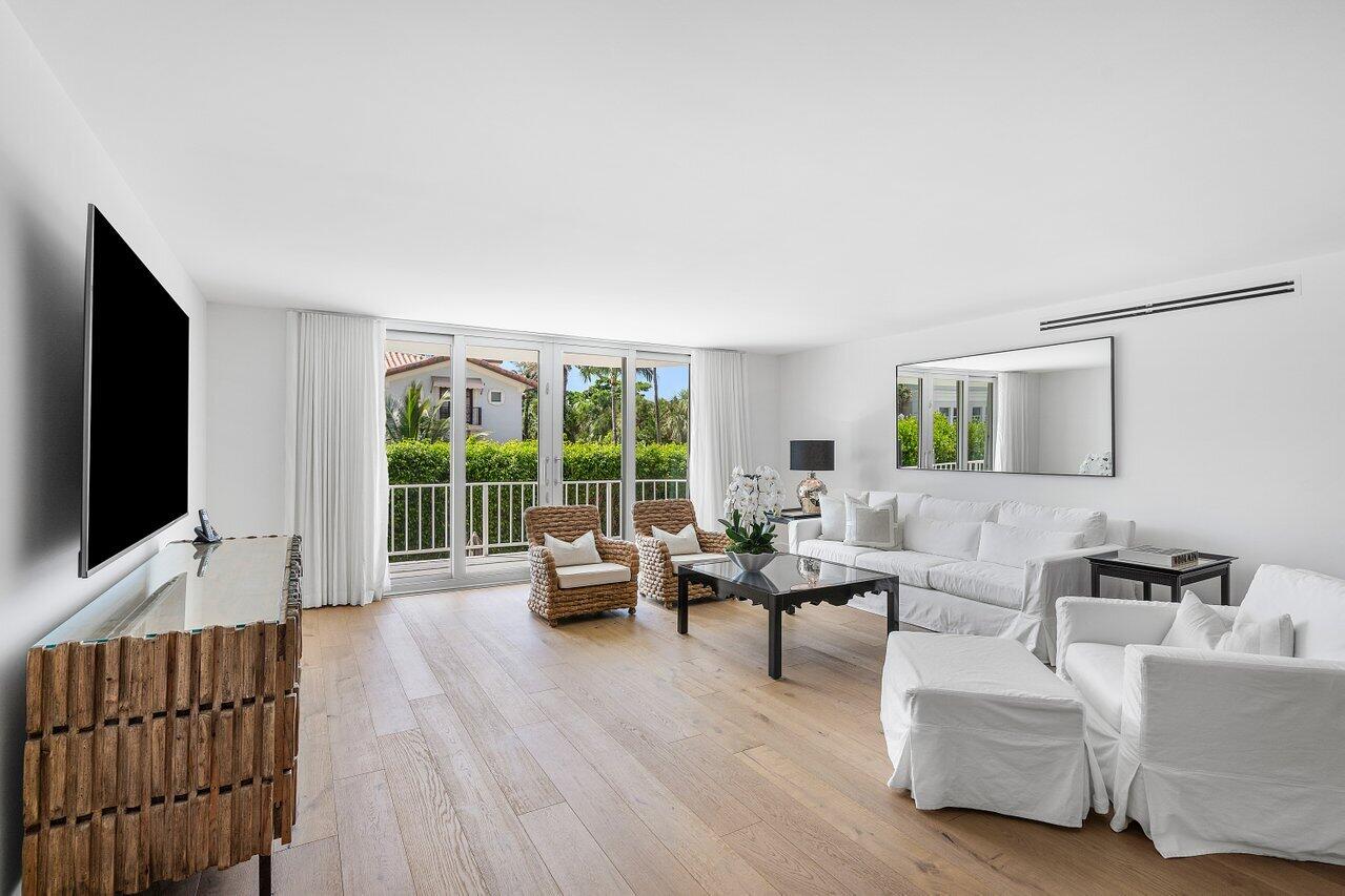 100 Worth Avenue, Unit 220 Palm Beach, FL 33480 - Photo 2 of 22 a living room with furniture floor to ceiling window hardwood floor and a flat screen tv