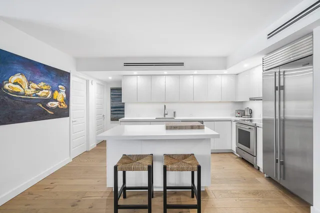 a kitchen with stainless steel appliances a stove a sink and a refrigerator