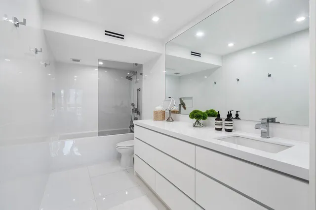 a bathroom with a double vanity sink toilet and shower