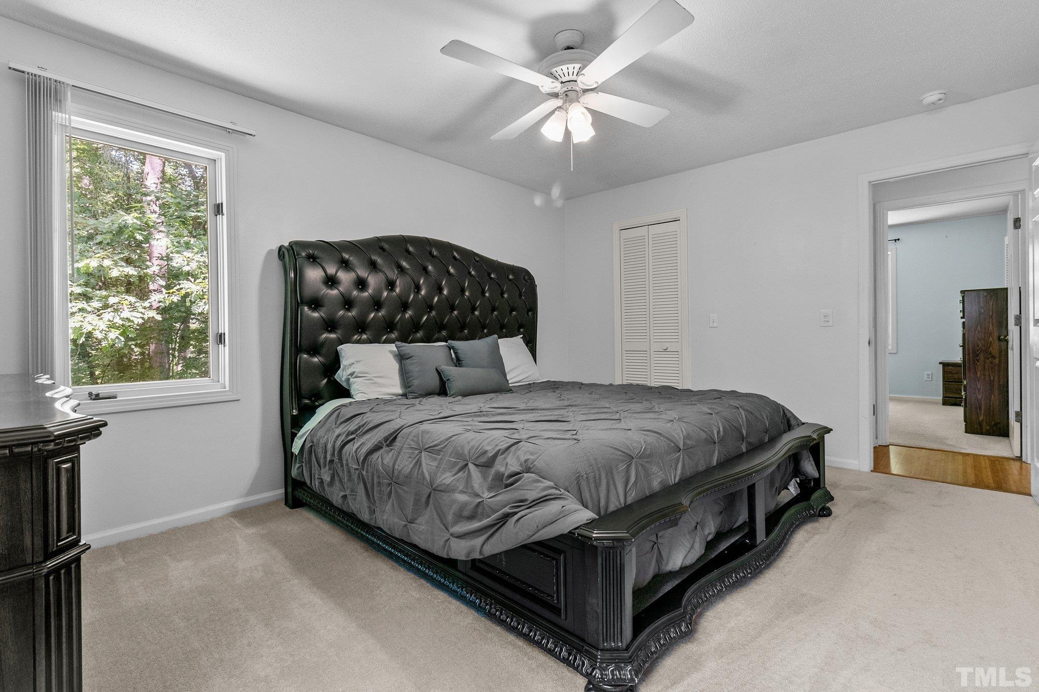 7068 Oak Road Sanford, NC 27332 - Photo 20 of 34 a spacious bedroom with a bed and a flat screen tv