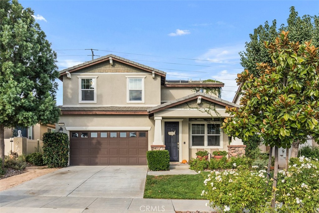 a front view of a house with a yard and trees