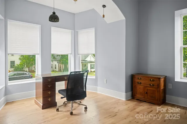 a view of a workspace with furniture and a window