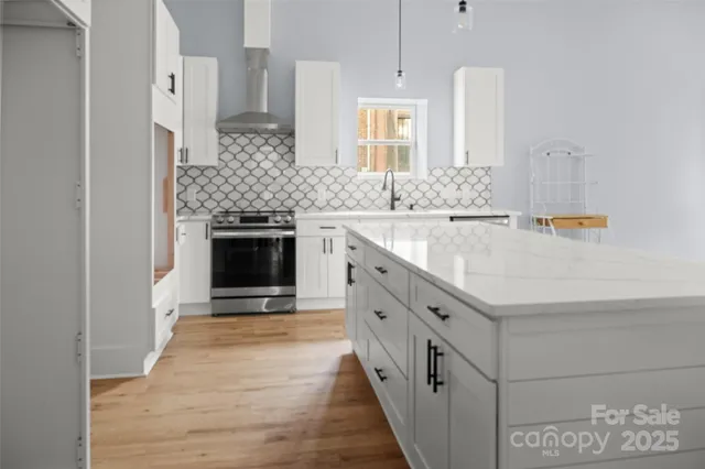 a kitchen with stainless steel appliances granite countertop a sink and a stove