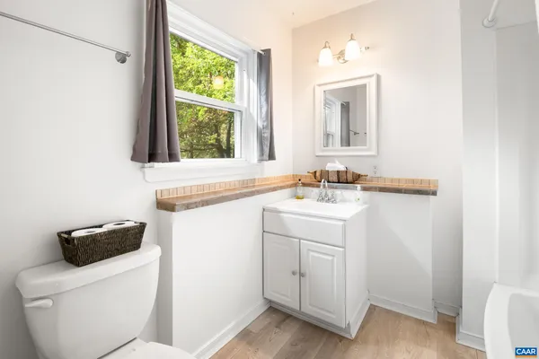 a bathroom with a sink a toilet and a window