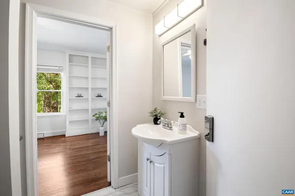 a bathroom with a sink a mirror and next to a window