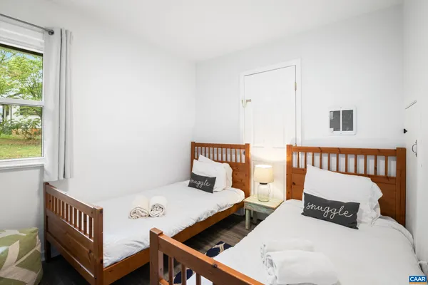 a bedroom with two beds and a window