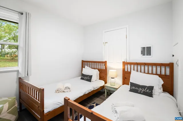 a bedroom with two beds and a window