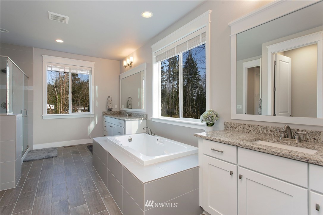 322 Graham Avenue Southeast Renton, WA 98059 - Photo 19 of 39 a view of a sink and mirror with wooden floor