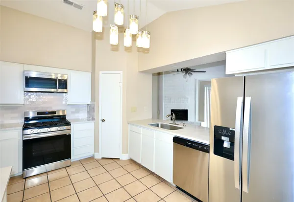 a kitchen with stainless steel appliances a stove a refrigerator and a sink