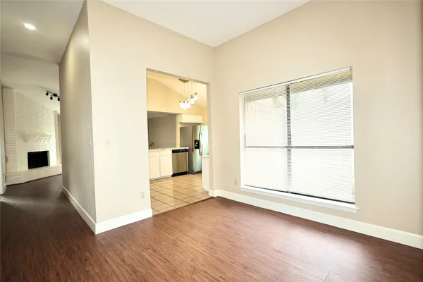 an empty room with wooden floor and a large window