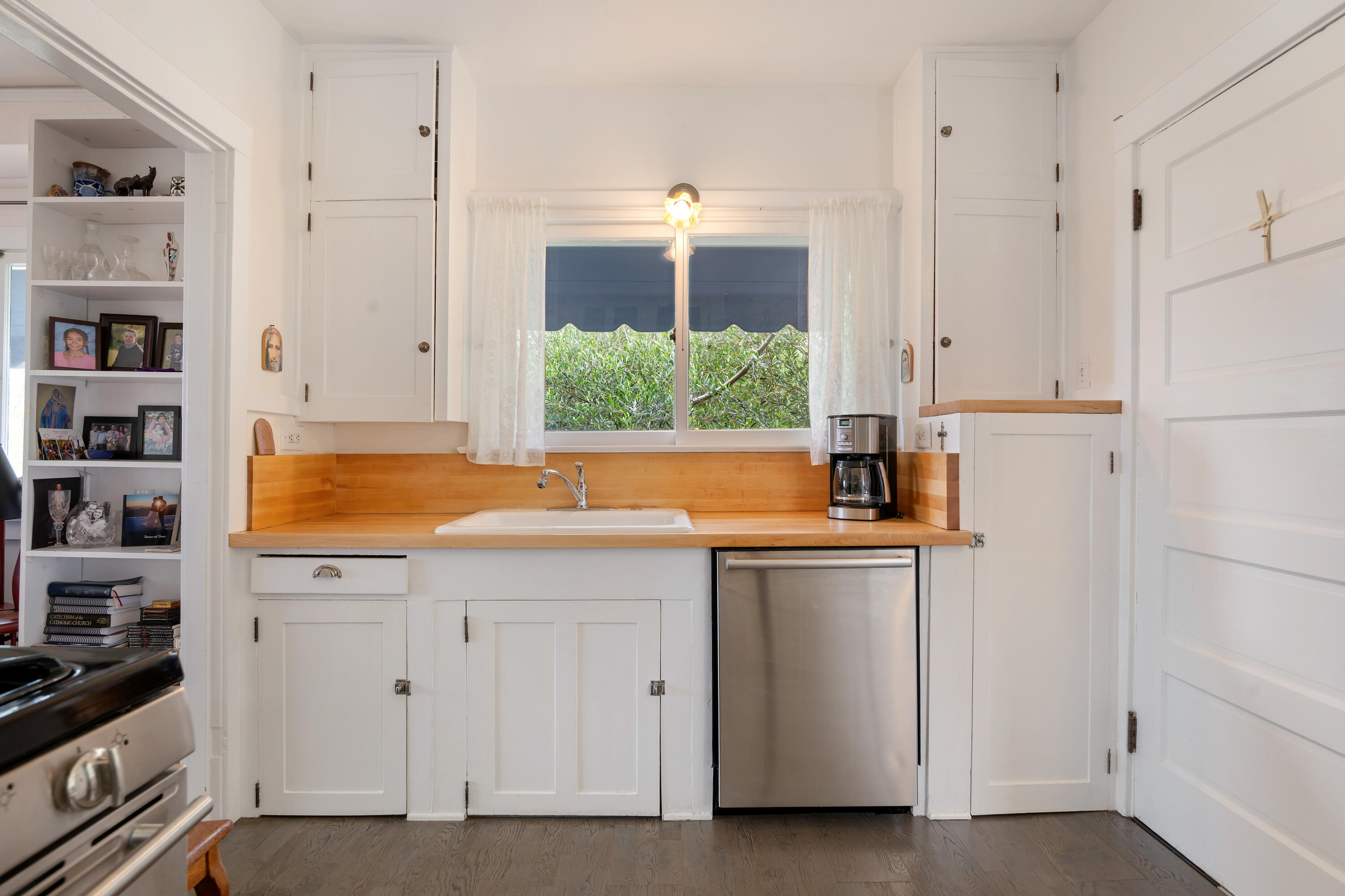 512 East Islay Street Santa Barbara, CA 93101 - Photo 11 of 25 a kitchen with stainless steel appliances white cabinets and a window