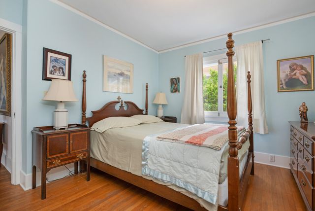 a bedroom with a bed and a table in it with window