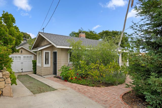 a view of a house with a yard and potted plants