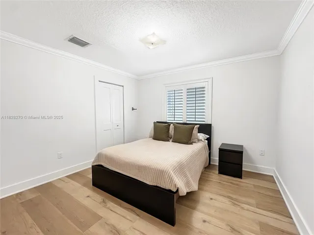 a bedroom with a bed and wooden floor