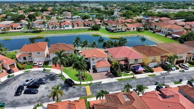 an aerial view of a houses with a garden and lake view
