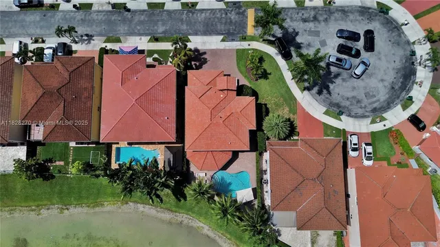 an aerial view of a house with yard and swimming pool