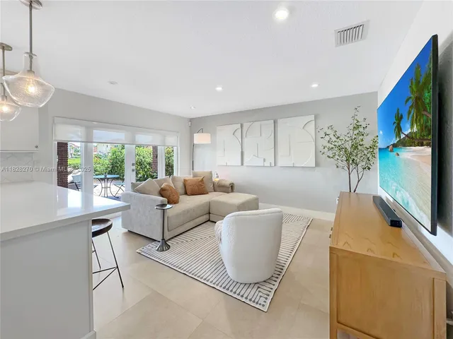 a living room with furniture a flat screen tv and a large window