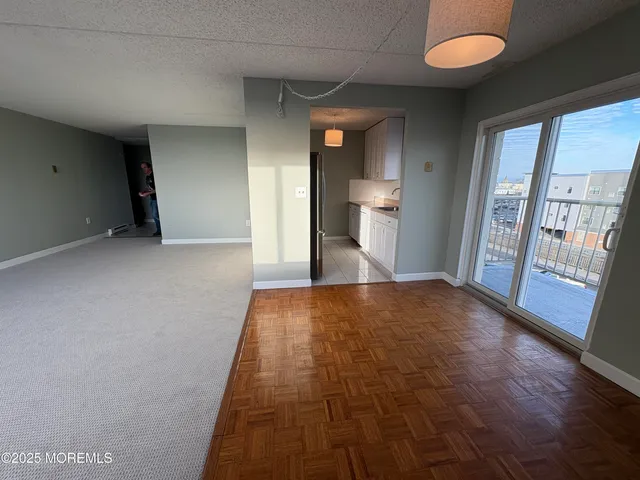 a view of hallway with wooden floor and bathroom