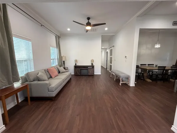 a living room with furniture and a wooden floor