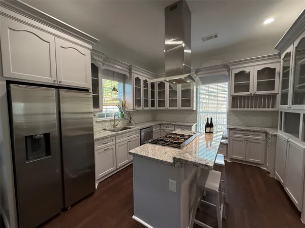 a kitchen with stainless steel appliances granite countertop a refrigerator a stove and a sink with cabinets