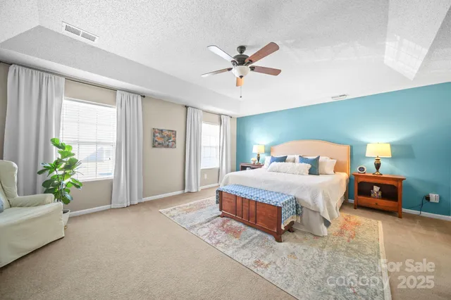 a bedroom with a large bed and a chandelier