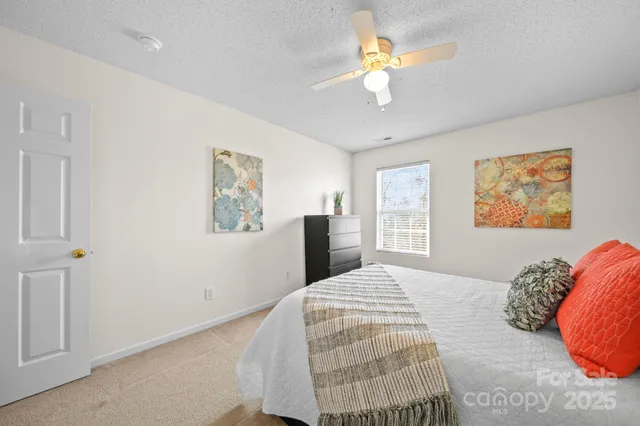 a bedroom with a large bed and a chandelier
