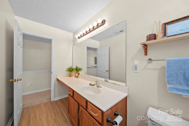 a bathroom with a sink a toilet a mirror and shower