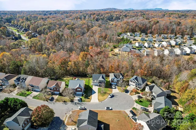 an aerial view of a houses with a swimming pool